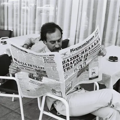 Man reading a newspaper at a café terrace in Athens, Greece 1979